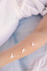 applying a soothing cream after the sugaring procedure. The final stage of hair removal. Heart-shaped moisturizing lotion for healthy skin. Sunscreen.