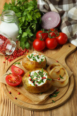 Concept of tasty food with baked potato on wooden table