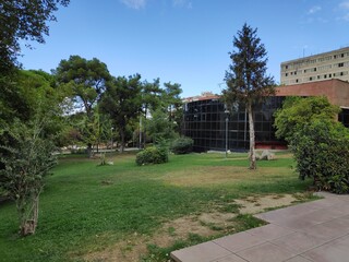 Garden surrounded by old trees in greenery next to the museum