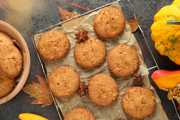 Concept of tasty food with pumpkin cookies on dark textured background