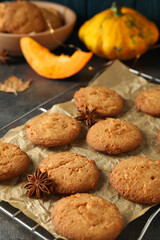 Concept of tasty food with pumpkin cookies on dark textured background