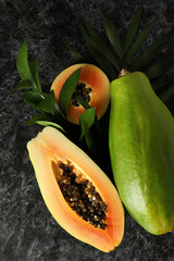 Ripe papaya with leaves on black smokey background