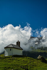 chapel in the swiss mountains with blue sky and clouds 