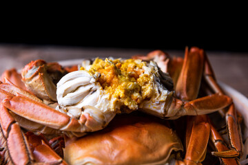 Cooked hairy crabs on the table, Closeup. The hairy crab and rich crab cream. - obrazy, fototapety, plakaty