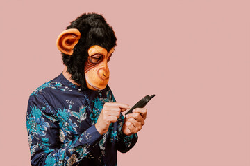 man wearing a monkey mask using a mobile phone © nito