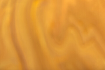Fototapeta na wymiar Blurred dark orange and golden background with wavy pattern. Defocused art abstract ocher gradient backdrop
