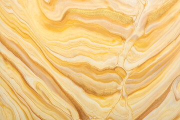 Abstract fluid art background light beige and golden colors. Liquid marble. Acrylic painting with yellow gradient