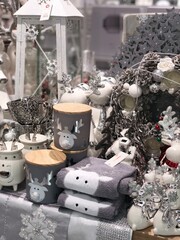Christmas decorations of a table in shop window in white and gray colors with reindeer print