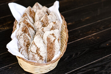 Small rye bread loafs in a basket at a restaurant