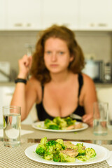 Plate with broccoli cabbage, girl in the background having lunch