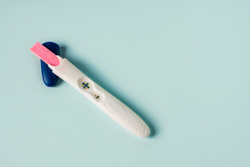 A positive pregnancy test on a blue background. Minimalism and a place for text
