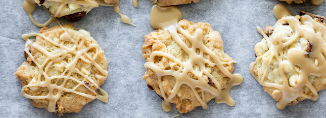 Top down narrow view of maple Vermont cookies drizzled with maple icing.