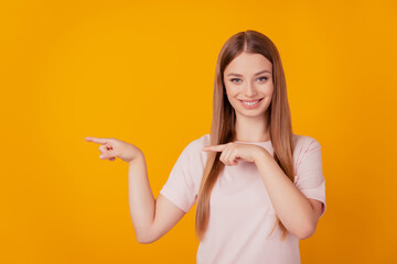 Portrait of shiny smart sweet lady demonstrate blank space with fingers on yellow background