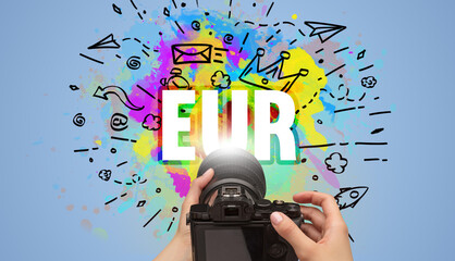 Close-up of a hand holding digital camera with abstract drawing