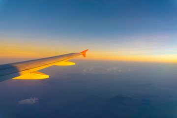 Obraz premium Wing of aircraft on sky with cloud sunset twilight