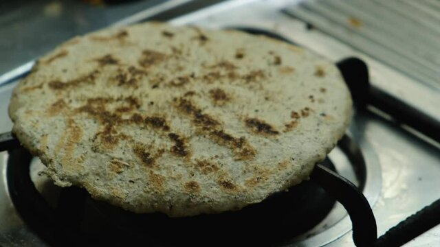 Bhakari ( a Maharashtrian authentic Bread ) is Roasted on a flame.
