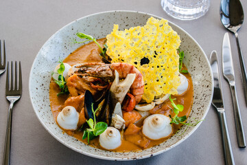 Fish stew with lobster, prawns and seafood foam at a restaurant