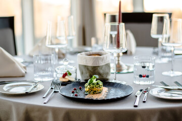 Colorful avocado tartar on a black plate at a restaurant