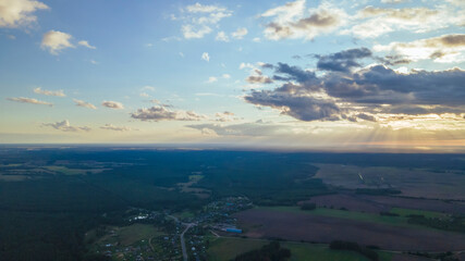 Top view of green fields, forest and cloudy blue sky in summer. Landscape with drone. Nature concept.