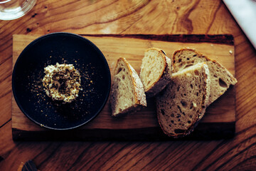 Bread and butter on a wooden plate at a restaurant