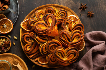 Sweet homemade cinnamon rolls in the shape of a heart on an old retro style. New Year mood. Traditional Swedish cinnabons. Selective focus