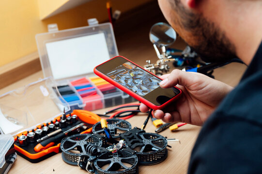 Man Repair A Drone.Engineer repairs a drone at home