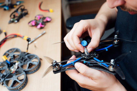 Man Repair A Drone.Engineer repairs a drone at home