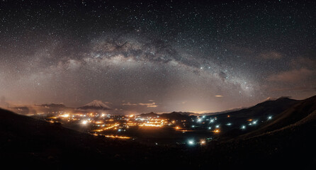 The milky way cover a little town in mountains with the star lights