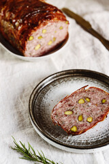 Terrine. Meatloaf. Traditional French cuisine loaf of meat, similar to a pâté, with bacon and pistachios. Selective focus