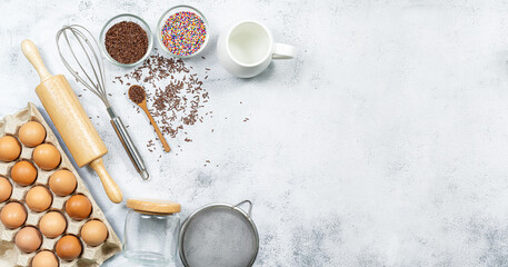 Preparation of the dough. A measurement of the amount of ingredients in the recipe. Ingredients for the dough: flour, eggs, rolling pin, whisk, milk, butter, cream. Top view, space for text