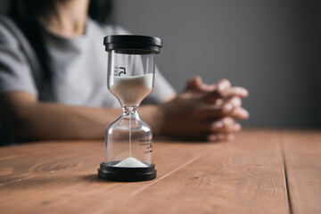 woman praying next to the hourglass