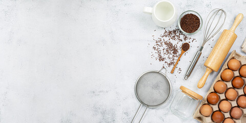 Preparation of the dough. A measurement of the amount of ingredients in the recipe. Ingredients for the dough: flour, eggs, rolling pin, whisk, milk, butter, cream. Top view, space for text