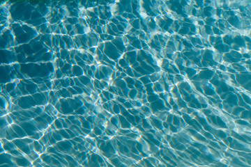 Fototapeta na wymiar Clear blue ripples on water in a swimming pool or sea