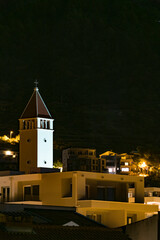 Makarska, Croatia, The Crkva Kraljice Mira church lit up at night on the hillside.