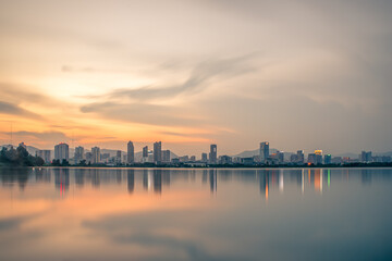 Fototapeta premium At dusk, the lake reflects the night view of the city
