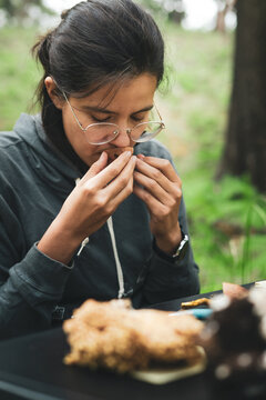 Female sniffing mushroom in nature