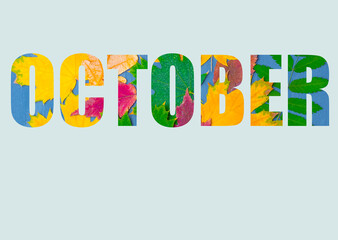 The word OCTOBER, composed of colorful autumn leaves of different plants, isolated on a pastel blue background.
