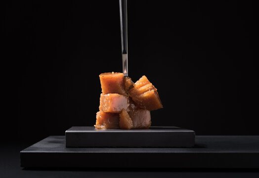 Gourmet quince jelly paste in ceramic plate on black background