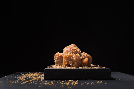 Gourmet quince jelly paste in ceramic plate on black background