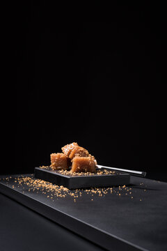 Gourmet quince jelly paste in ceramic plate on black background