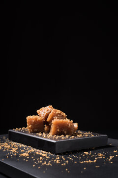 Gourmet quince jelly paste in ceramic plate on black background