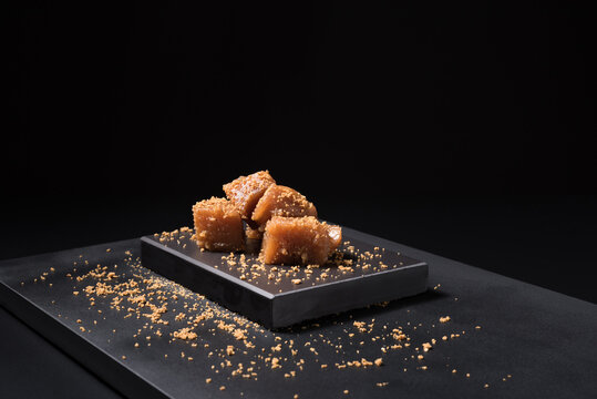 Gourmet quince jelly paste in ceramic plate on black background