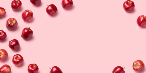 Red apples on pink background. Pattern, top view, flat lay, copy space.