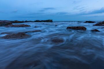 Fototapeta na wymiar In the evening, the sea slapped the rocks