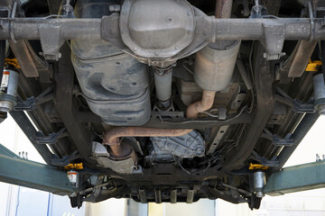 A modern powerful car in a car service on a lift. Service, repair, spare parts. Selected focus.