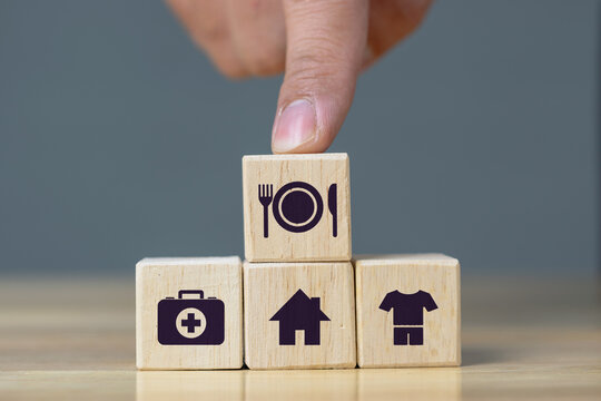 human hand placing cube with food Clothing, housing, medicine, four basic human needs concept.