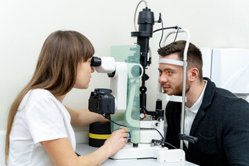Optometrist working at his clinic examining eye vision. Ophtalmology medical healthcare diagnostic.