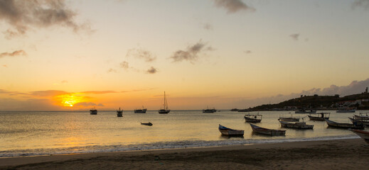 Boats at sea, backlit, at sunset time
