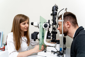 Ophtalmology medical healthcare diagnostic. Optometrist working at his clinic examining eye vision.