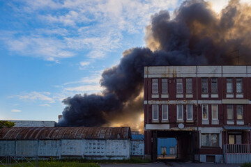 Fire in old factory. Puffs of black smoke from fire. Industrial accident in factory. Top view of...